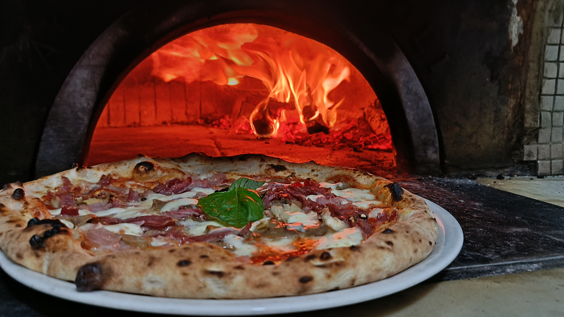 Pizza napoletana appena sfornata dal forno a legna